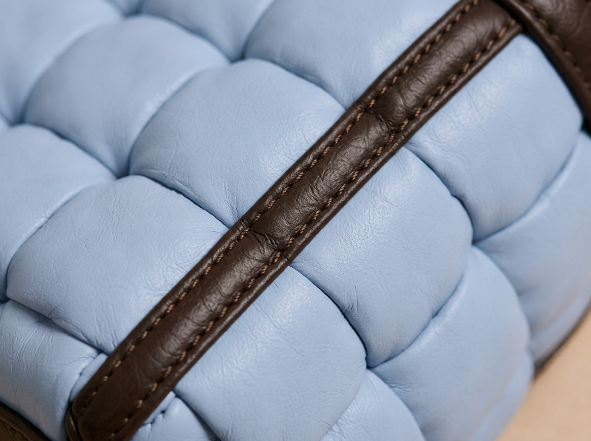 Macro du tressage matelassé : lanières de cuir entrelacées et coutures ton sur ton